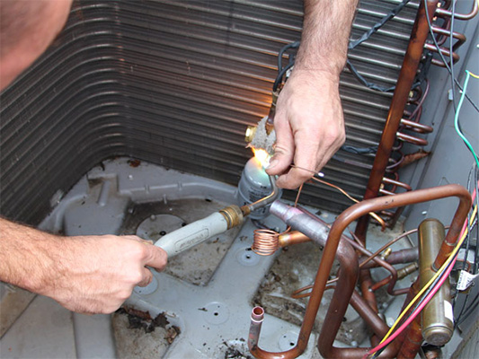 Technician repairing a heat pump