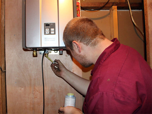 Male technician installing a tankless water heater
