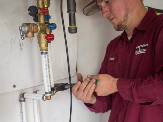 Male technician providing water heater installation