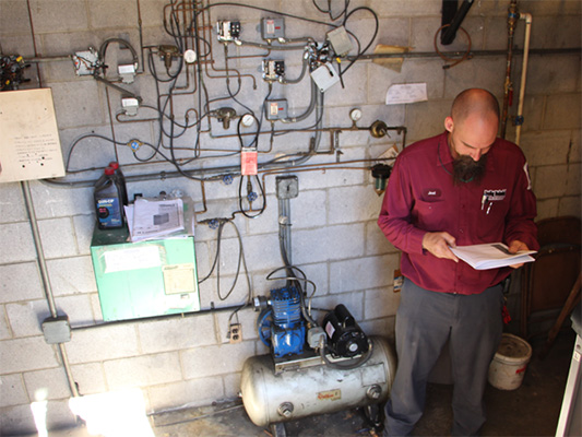 Male technician providing water heater maintenance